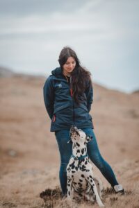 a woman standing next to a dalmatian dog
